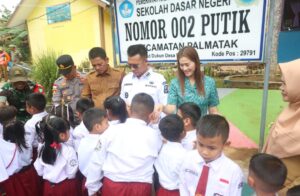 Bupati Anambas Aneng di dampingi Wakil Bupati Anambas Raja Bayu dan Ketua TP-PKK Anambas Ny. Sinta saat Penyerahan Bantuan Seragam di SDN 002 Putik