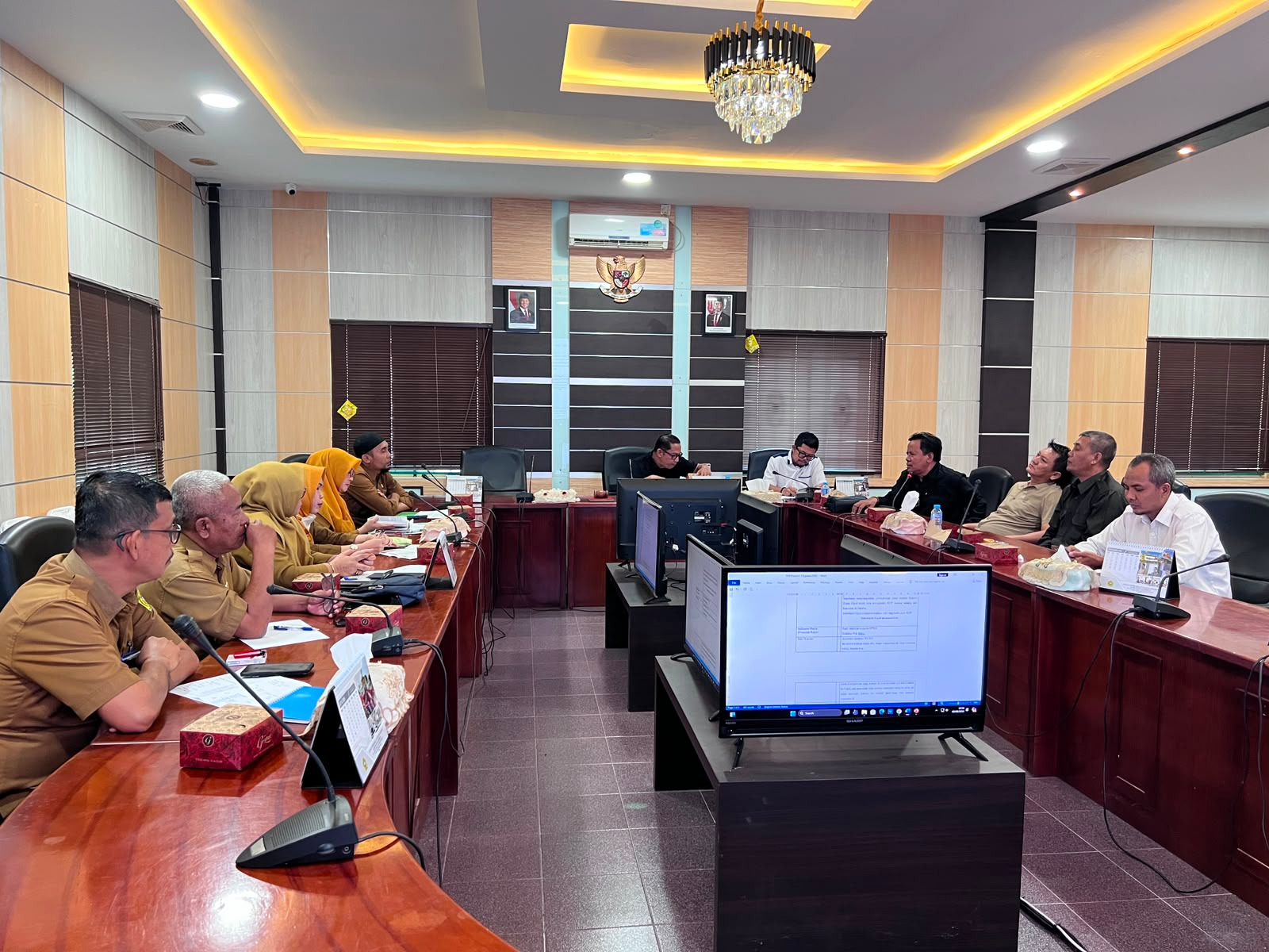 Jalannya RDP. Jajaran lengkap Komisi I DPRD Karimun dan tim Disdukcapil (termasuk kelima petugas berhijab kuning) duduk rapi di meja kayu yang panjang. Pertemuan ini menandai langkah penting koordinasi lintas sektoral untuk percepatan layanan Adminduk yang inklusif di seluruh wilayah kepulauan Karimun – Foto: Sekwan DPRD Karimun