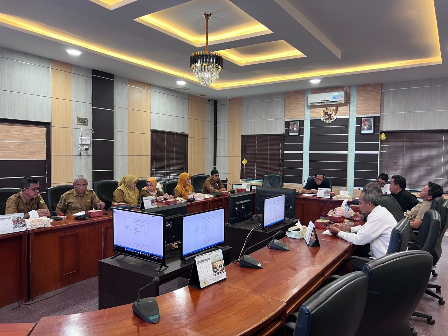 Meja rapat kayu yang panjang mendominasi ruangan, memperlihatkan sinergi penuh antara semua individu yang hadir dari Komisi I DPRD dan Disdukcapil (termasuk kelima petugas berhijab kuning) – Foto: Sekwan DPRD Karimun