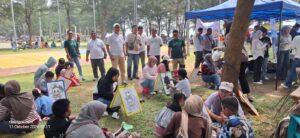 Jufriadi (berkaos dan topi putih) saat melihat antusiasme anak anak saat melakukan kegiatam mewarnai gambar yang di sediakan olehnya pada kegiatan promosi aplikasi digital tring!