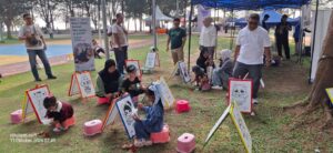 Hanin (6) siswi SD Negeri 02 Ranai bersama adiknya Ame (2) yang dengan keceriaannya melakukan kegiatan mewarnai gambar yang di sediakan oleh PT. Pegadaian Cabang Natuna di lolasi bootr pelayanan dan promosi aplikasi digital Tring! di Pantai Piwang yang di sejalanlan dengan kegiatan pawai budaya oleh Pemerintah Kabupaten Natuna dalam rangka kemeriahan HUT Natuna ke 27