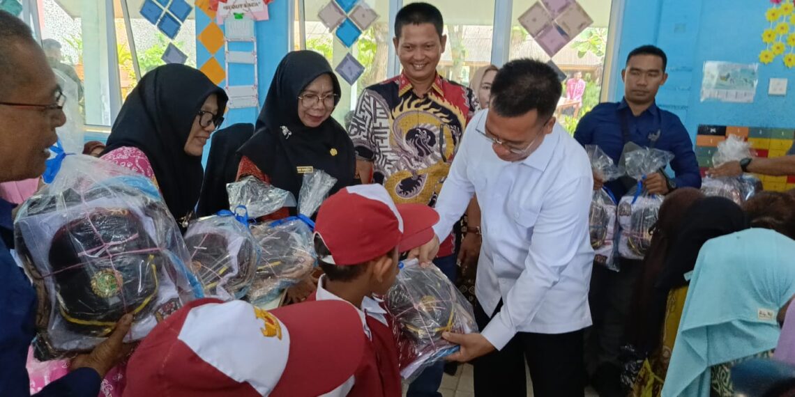Bupati Anambas saat Serahkan bantuan seragam ke siswa