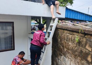 Saat petugas Damkar melakukan penyelamatan seorang anak yang terjebak di atap rumah