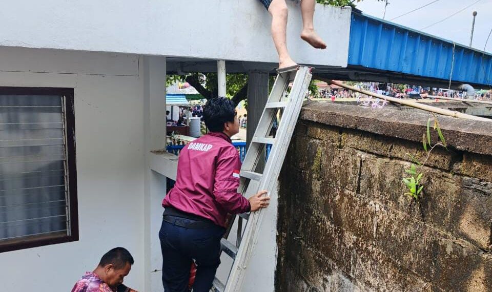 Saat petugas Damkar melakukan penyelamatan seorang anak yang terjebak di atap rumah