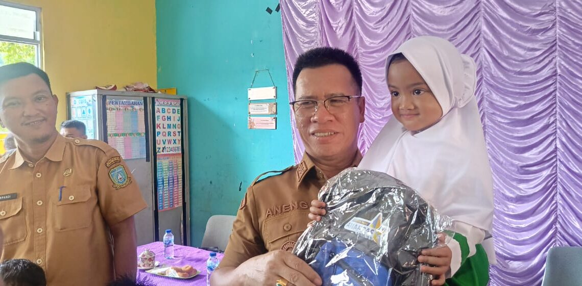 Bupati Anambas saat menggendong murid Paud saat serahkan bantuan