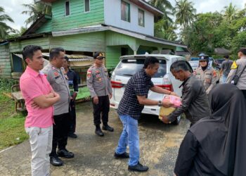 Panit I Intelkam Aipda Teddy Saputra saat menyerahkan bantuan kepada penerima manfaat