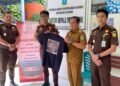 Penyerahan bagi bagi kaos di hari Anti Korupsi di desa putik oleh Kasintel Kejari Anambas