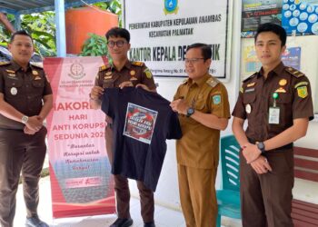 Penyerahan bagi bagi kaos di hari Anti Korupsi di desa putik oleh Kasintel Kejari Anambas