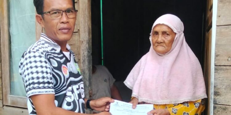 Kades Sunggak Nurizal Damri Saat Serahkan Bantuan uang Tunai dari Baznas kepala warga penerima