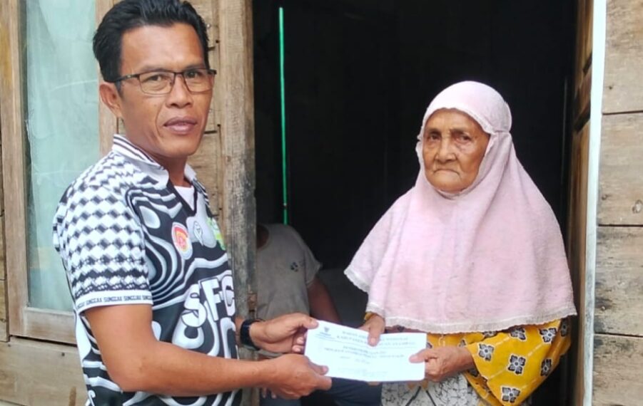 Kades Sunggak Nurizal Damri Saat Serahkan Bantuan uang Tunai dari Baznas kepala warga penerima