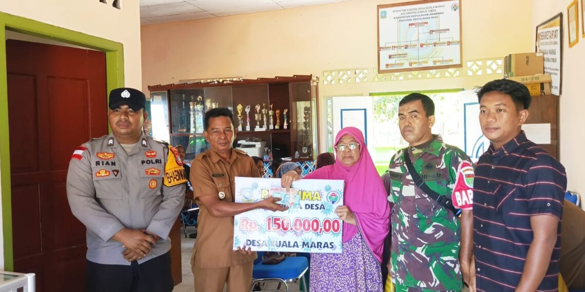 Kades Kuala Maras Hendrika saat salurkan bantuan ke kepada warga penerima di dampingi Ketua BPD Babinsa bhabinkamtibmas