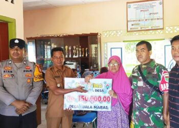 Kades Kuala Maras Hendrika saat salurkan bantuan ke kepada warga penerima di dampingi Ketua BPD Babinsa bhabinkamtibmas