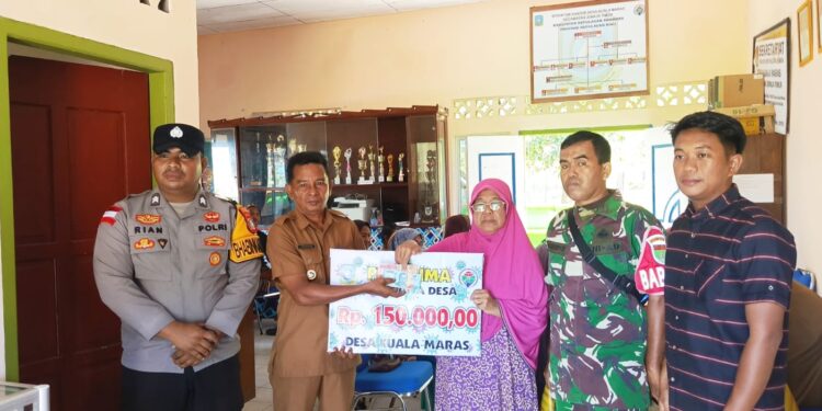 Kades Kuala Maras Hendrika saat salurkan bantuan ke kepada warga penerima di dampingi Ketua BPD Babinsa bhabinkamtibmas