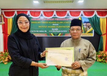 Tim penilai Dr. Riska Puspita Sari, M.Pd saat menyerahkan surat tanda telah dilaksanalannya Asesmen Lapangan Perubahan Bentuk STAI Natuna untuk menjadi Institut Agama Islam Natuna kepada Ketua STAI Natuna, Dr. H. Umar Natuna, S.Ag., M.Pd.I