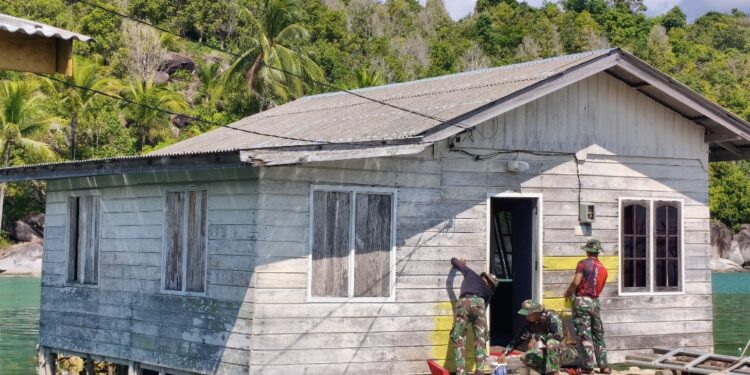 Anggota TNI saat Lakukan pengecatan rumah RTLH dalam program TMMD ke-128, personel Kodim 0318/Natuna di Anambas