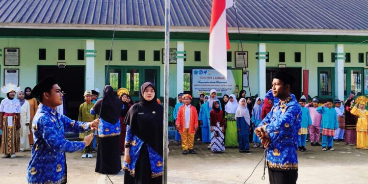 Pengibaran Bendera Merah Putih oleh ASN SDN 009 Landak di Hari Upacara Hardiknas