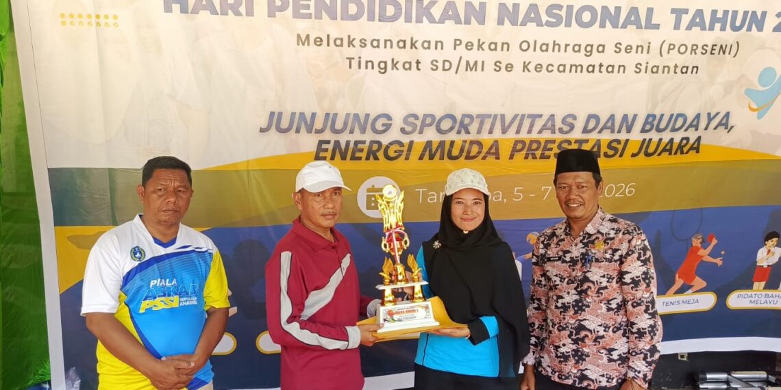 Ketua Panitia Sri Widarti Sulistya saat serahkan piala juara umum kepada Kepala sekolah SDN 02 Siantan di kegiatan Porseni Hardiknas 2026 di lapangan Sulaiman Abdullah