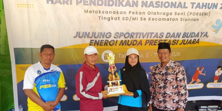 Ketua Panitia Sri Widarti Sulistya saat serahkan piala juara umum kepada Kepala sekolah SDN 02 Siantan di kegiatan Porseni Hardiknas 2026 di lapangan Sulaiman Abdullah