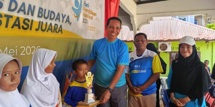 Kepala Dinas Pendidikan Pemuda dan olahraga Toni Karnain saat serahkan piala juara
