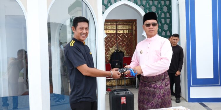 Bupati Anambas Aneng saat serahkan Bantuan secara simbolis kepada kepala Desa Tarempa Barat Asmarandi