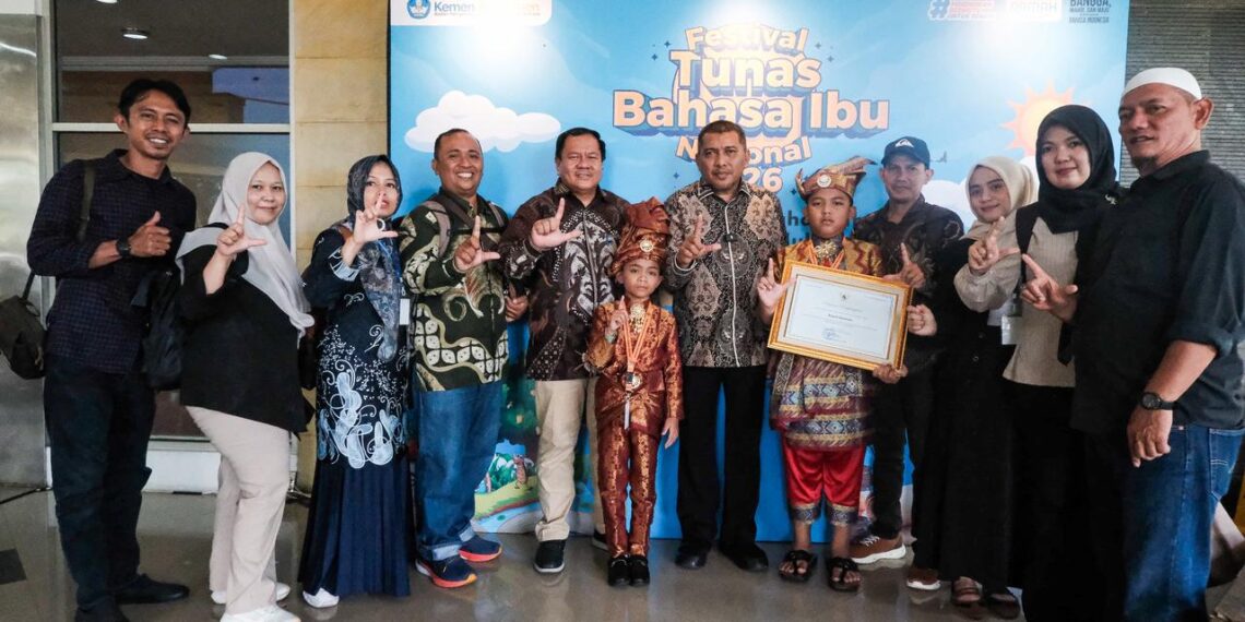 Wakil Bupati Karimun, Rocky Marciano Bawole foto bersama Kepala Dinas Pendidikan Kabupaten Karimun, Grandy Regel Tuerah serta pelajar dan masyarakat, usai menerima Penghargaan Revitalisasi Bahasa Daerah Tahun 2026 dari Mendikdasmen RI - Foto: Diskominfo Karimun