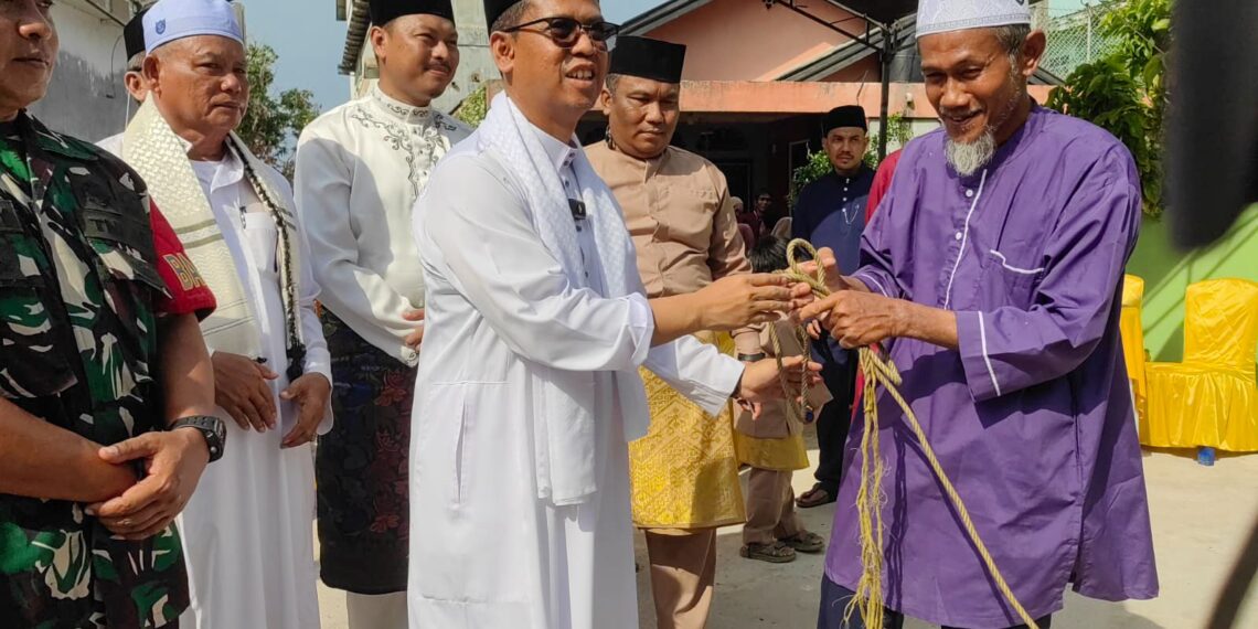 Bupati Karimun, Ing Iskandarsyah menyerahkan bantuan dua ekor sapi kurban dari Presiden Republik Indonesia kepada panitia kurban di Kecamatan Moro, usai pelaksanaan Sholat Idul Adha 1447 H - Foto: Diskominfo Karimun