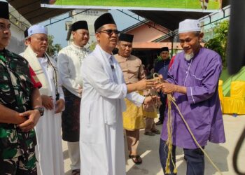 Bupati Karimun, Ing Iskandarsyah menyerahkan bantuan dua ekor sapi kurban dari Presiden Republik Indonesia kepada panitia kurban di Kecamatan Moro, usai pelaksanaan Sholat Idul Adha 1447 H - Foto: Diskominfo Karimun