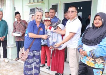 Bupati Anambas Aneng didampingi wakil Bupati Raja Bayu bersama wisatawan Mrs. Meggy serahkan bantuan kepada Siswa Sekolah Dasar di Desa telaga Besar
