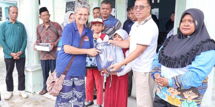 Bupati Anambas Aneng didampingi wakil Bupati Raja Bayu bersama wisatawan Mrs. Meggy serahkan bantuan kepada Siswa Sekolah Dasar di Desa telaga Besar