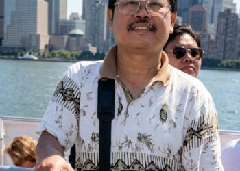 Itu Foto saya dengan latar belakang Menara Kembar dan kota New York, Pak Rapi, 27 Agustus 2001, sebelum peristiwa 9/11.