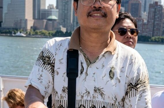 Itu Foto saya dengan latar belakang Menara Kembar dan kota New York, Pak Rapi, 27 Agustus 2001, sebelum peristiwa 9/11.