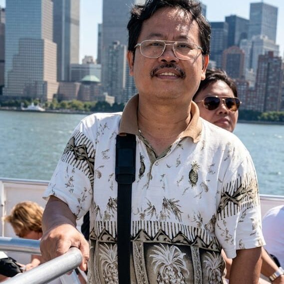 Itu Foto saya dengan latar belakang Menara Kembar dan kota New York, Pak Rapi, 27 Agustus 2001, sebelum peristiwa 9/11.