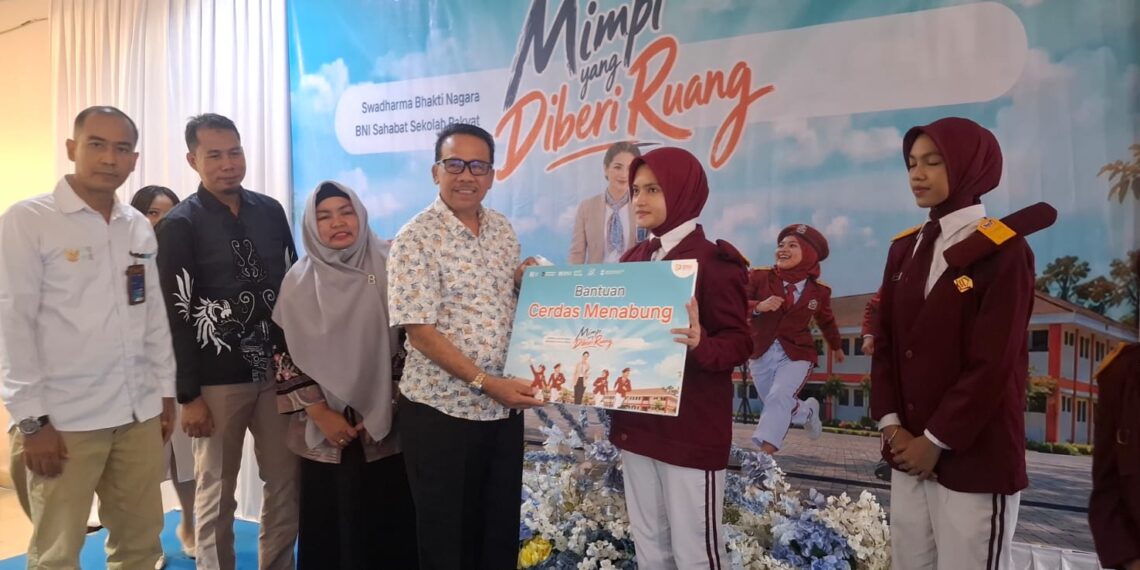 Wakil Bupati Natuna, Jarmim, SE saat menyerahkan bantuan beasiswa kepada siswa berprestasi dari program CSR Bank BNI dalam rangka HUT BNI ke 80