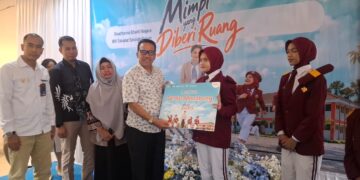 Wakil Bupati Natuna, Jarmim, SE saat menyerahkan bantuan beasiswa kepada siswa berprestasi dari program CSR Bank BNI dalam rangka HUT BNI ke 80